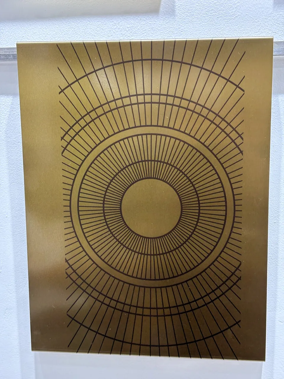 Etched sunburst pattern on a gold stainless steel sheet